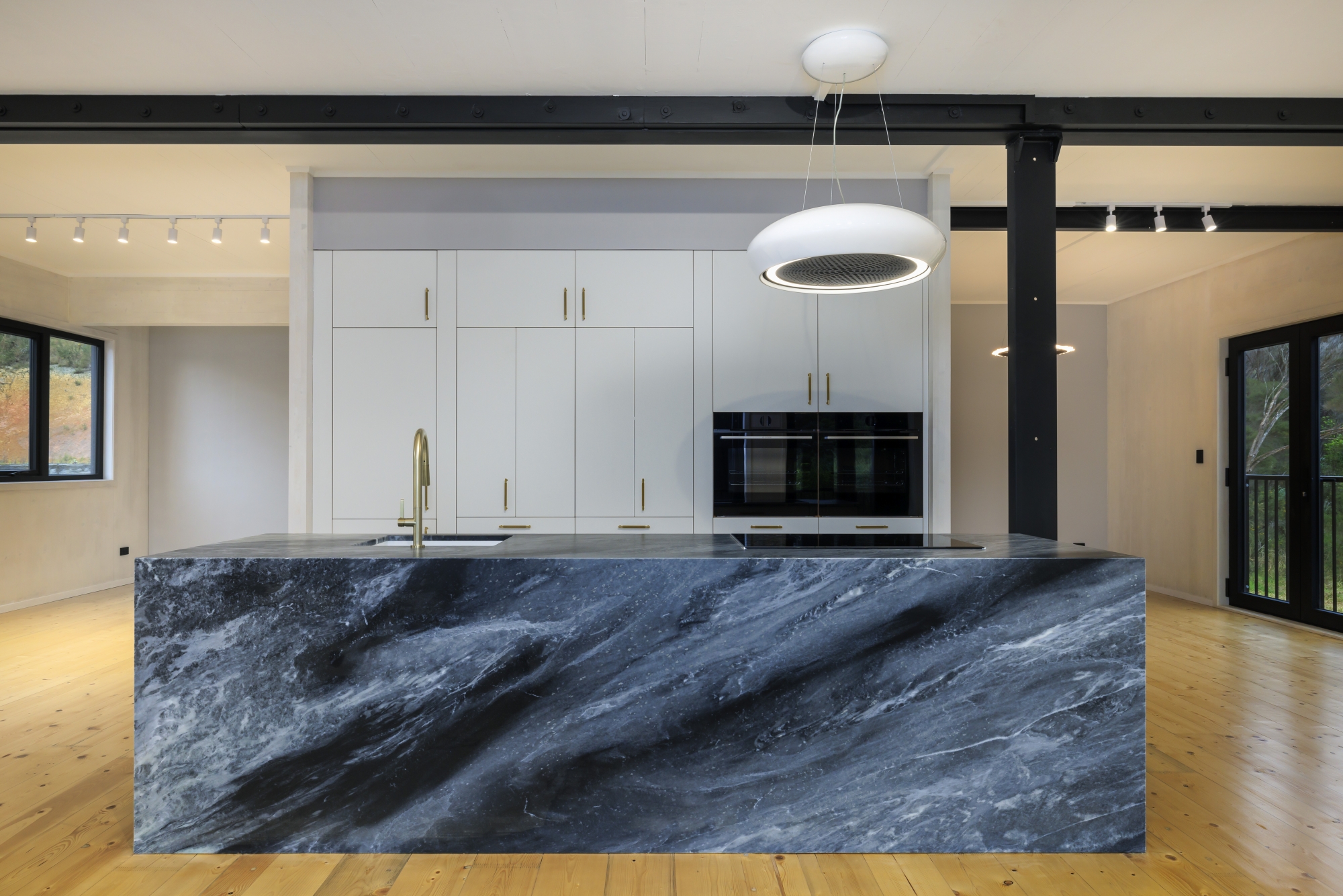 Kitchen with dark stone island and timber flooring in a Real Wood Homes build